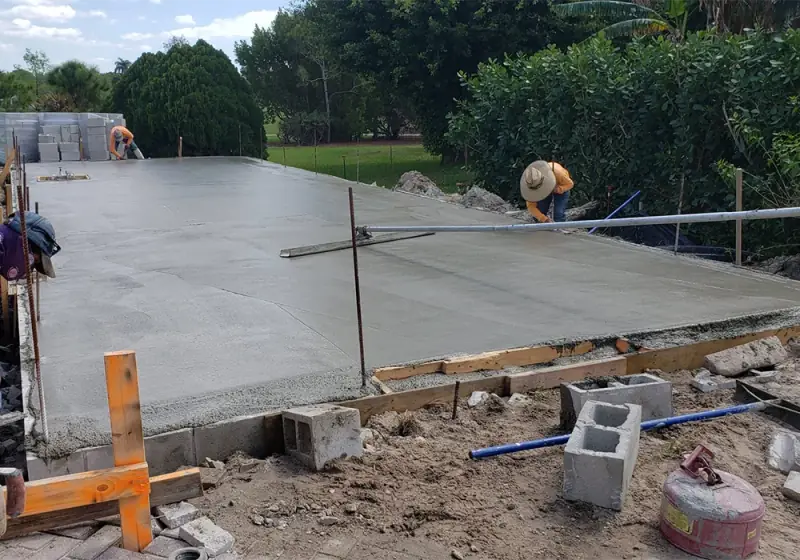 Crew screeding a freshly poured concrete slab
