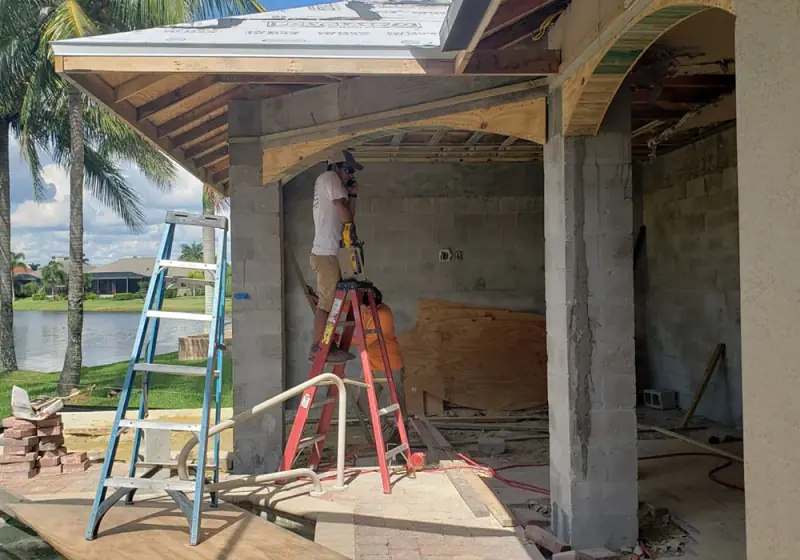 Covered patio structure with concrete columns and beam under construction