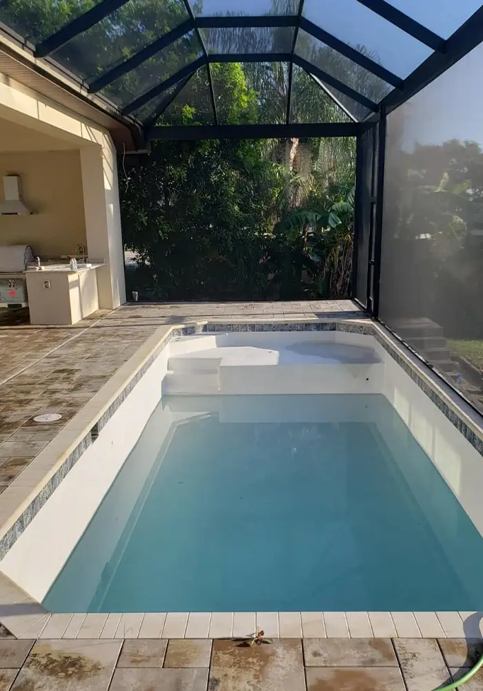 Lap pool with a paver deck inside a screen enclosure