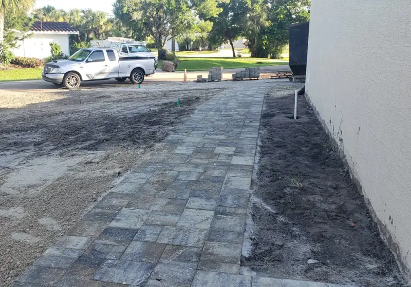 Paver walkway being installed along the side of a home