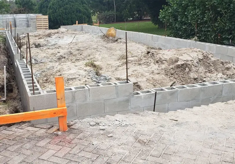 Block wall perimeter set on footings before fill