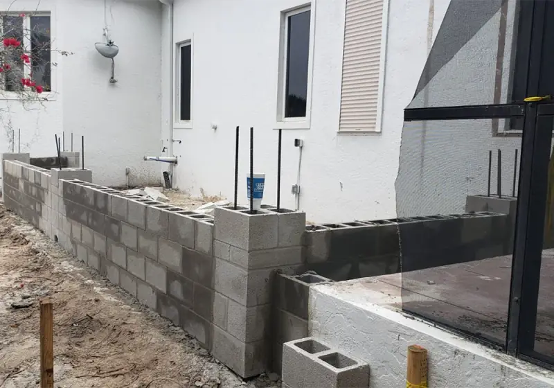 Block stem wall with vertical rebar dowels along an existing home