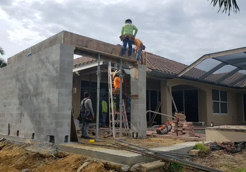 Crew setting tie beam forms with shoring on a block addition